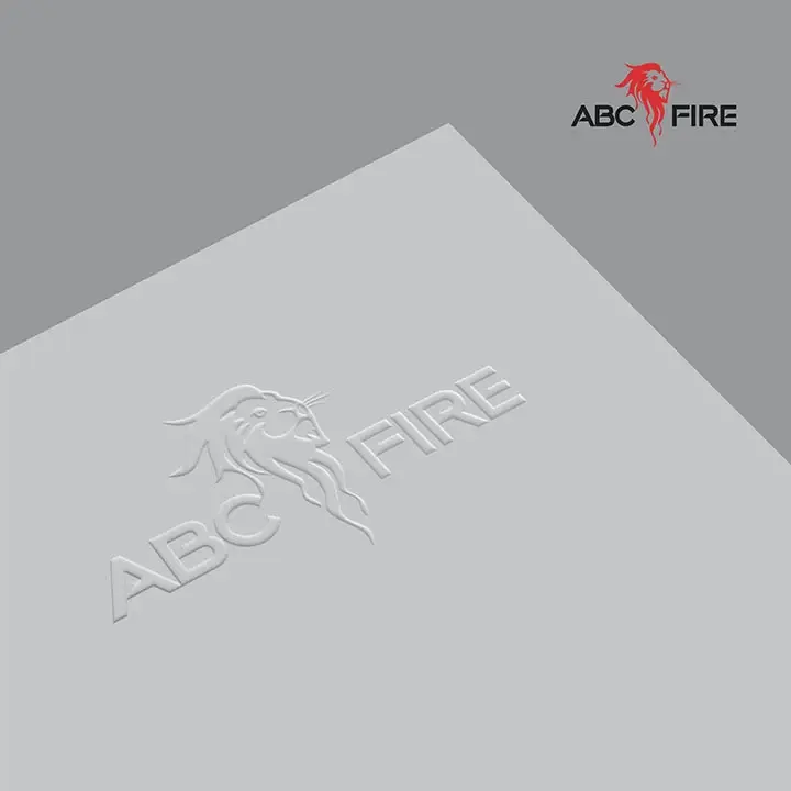ABC Fire - lion mark and wordmark embossed in white-on-white on grey card, showing the mark at its most refined