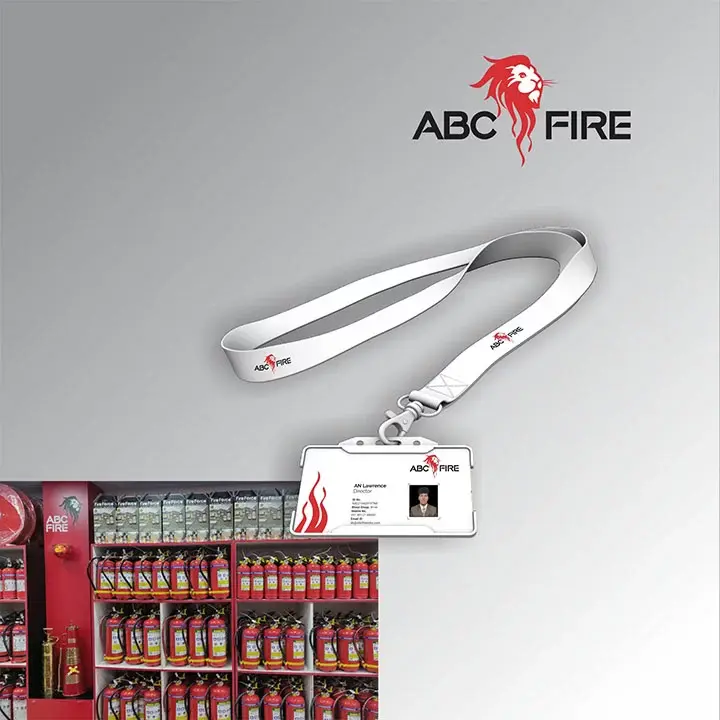ABC Fire - staff ID card on white branded lanyard, store shelf stocked with red fire extinguishers visible in background
