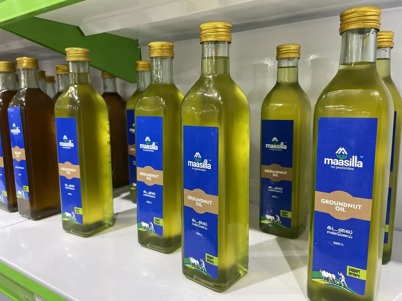 Maasilla groundnut oil - cold-pressed, 500ml glass bottle with paper-and-blue label and Support Farmers illustration